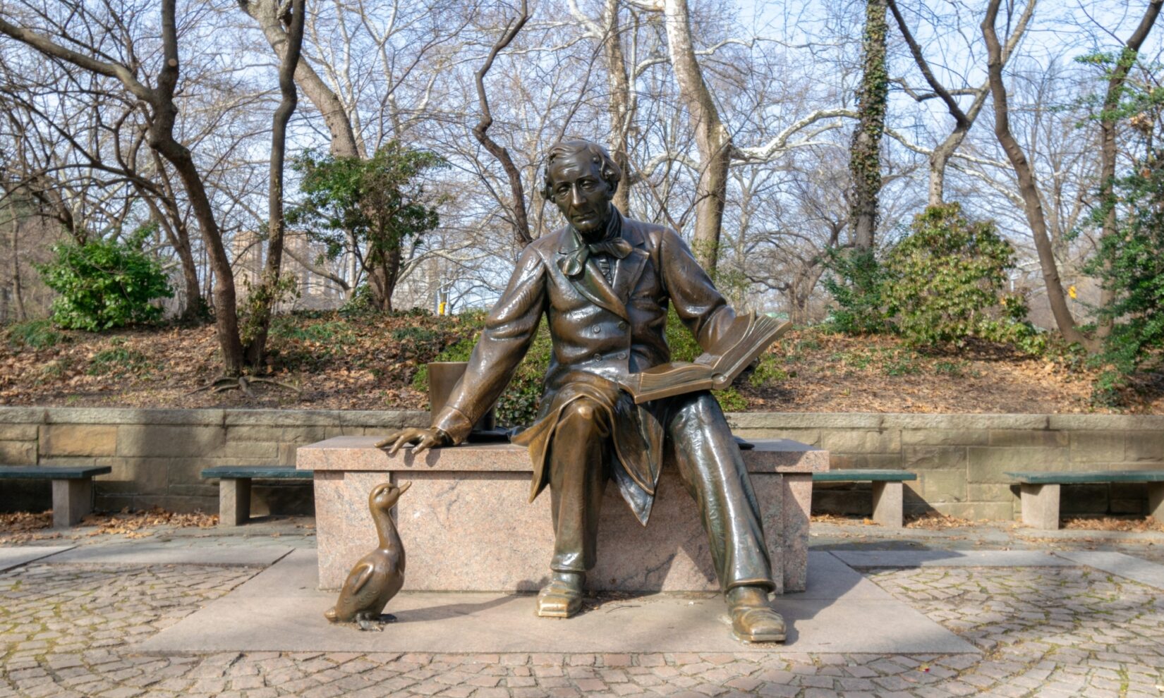 George Delacorte seated on the lap of the Alice in Wonderland statue